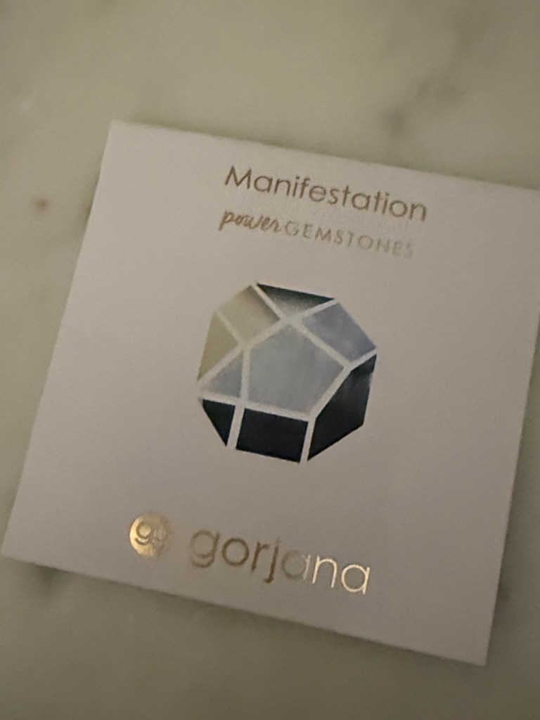 Gorjana White Card With Metallic Gold Logo And Blue Gem Graphic